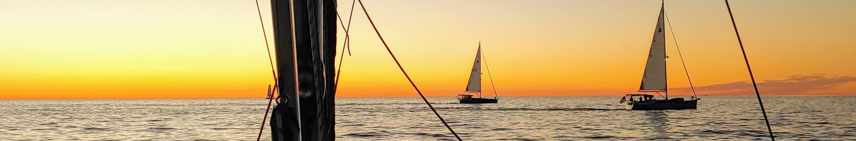 Sailboats at sunset on calm water